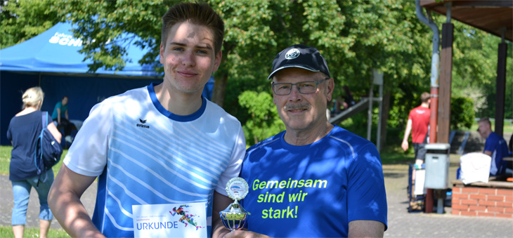 Janis Hammel und sein Trainer Helmut Zülch halten stolz einen Siegerpokal in den Händen